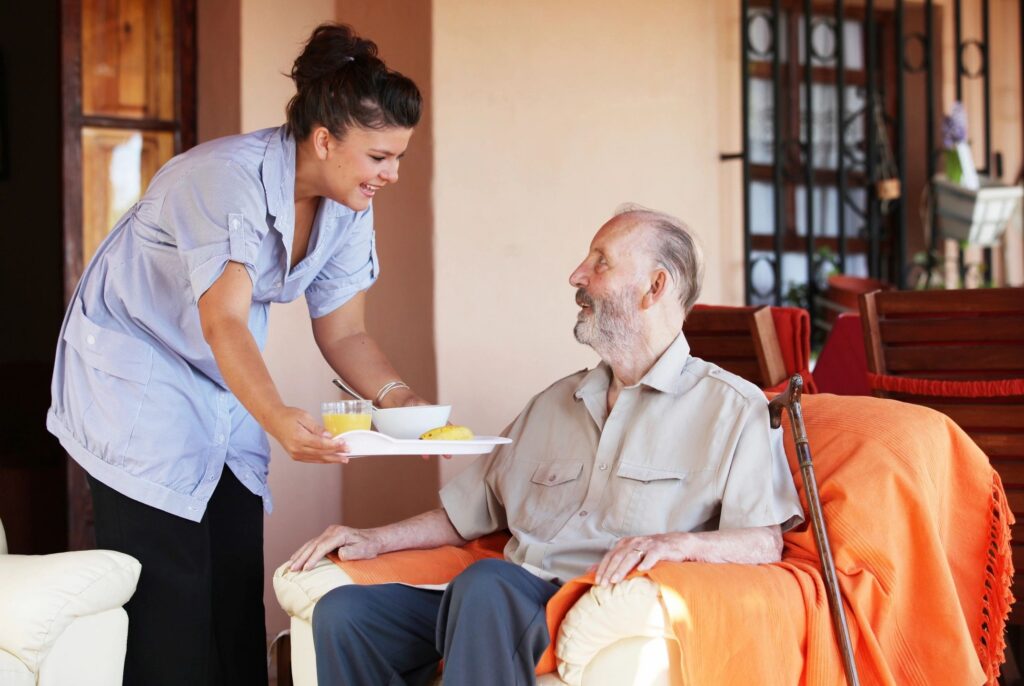 Woman serving breakfast tray to seated man